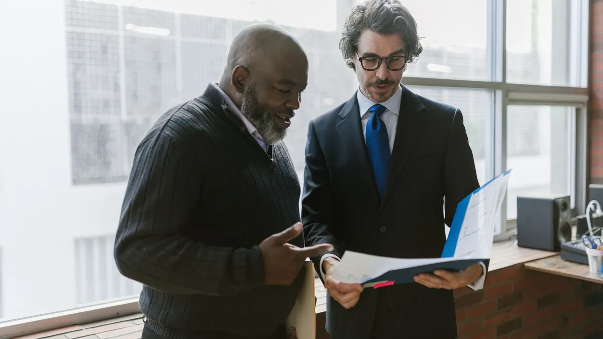 Consultor e cliente conferindo documentos juntos no escritório