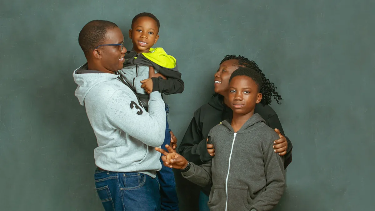 Família com pais e dois filhos sorrindo juntos
