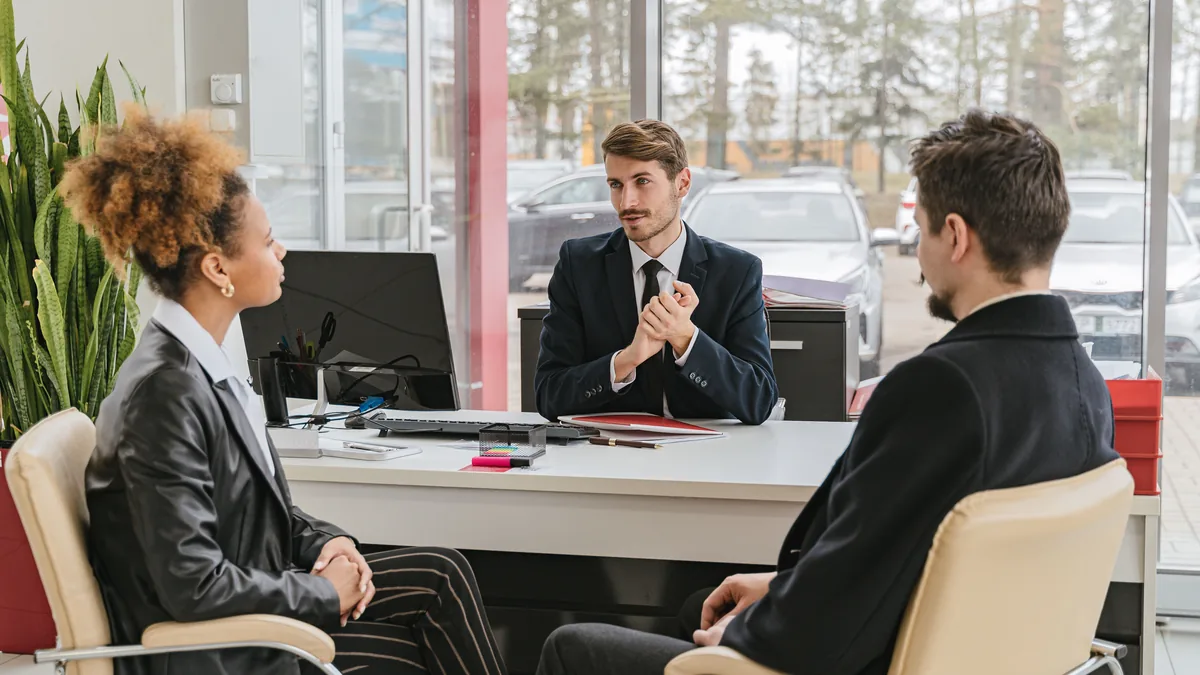 Consultor conversando com clientes em uma reunião de escritório