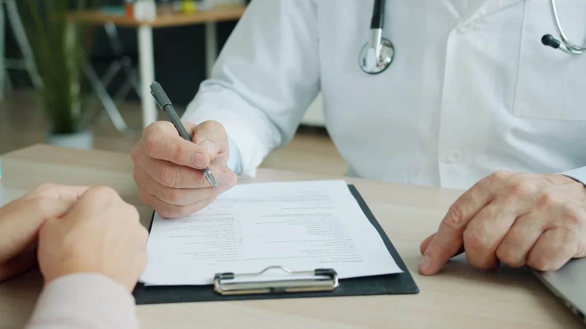Médico e paciente revisando documentos em uma consulta