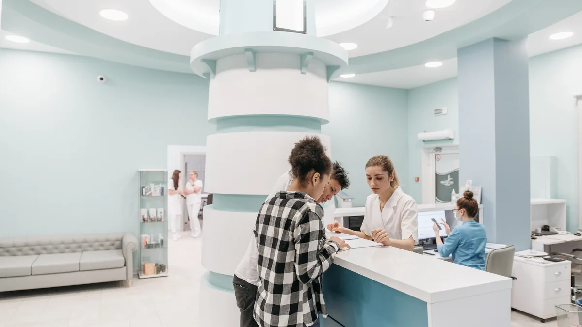 Recepção de um hospital moderno com profissionais de saúde atendendo